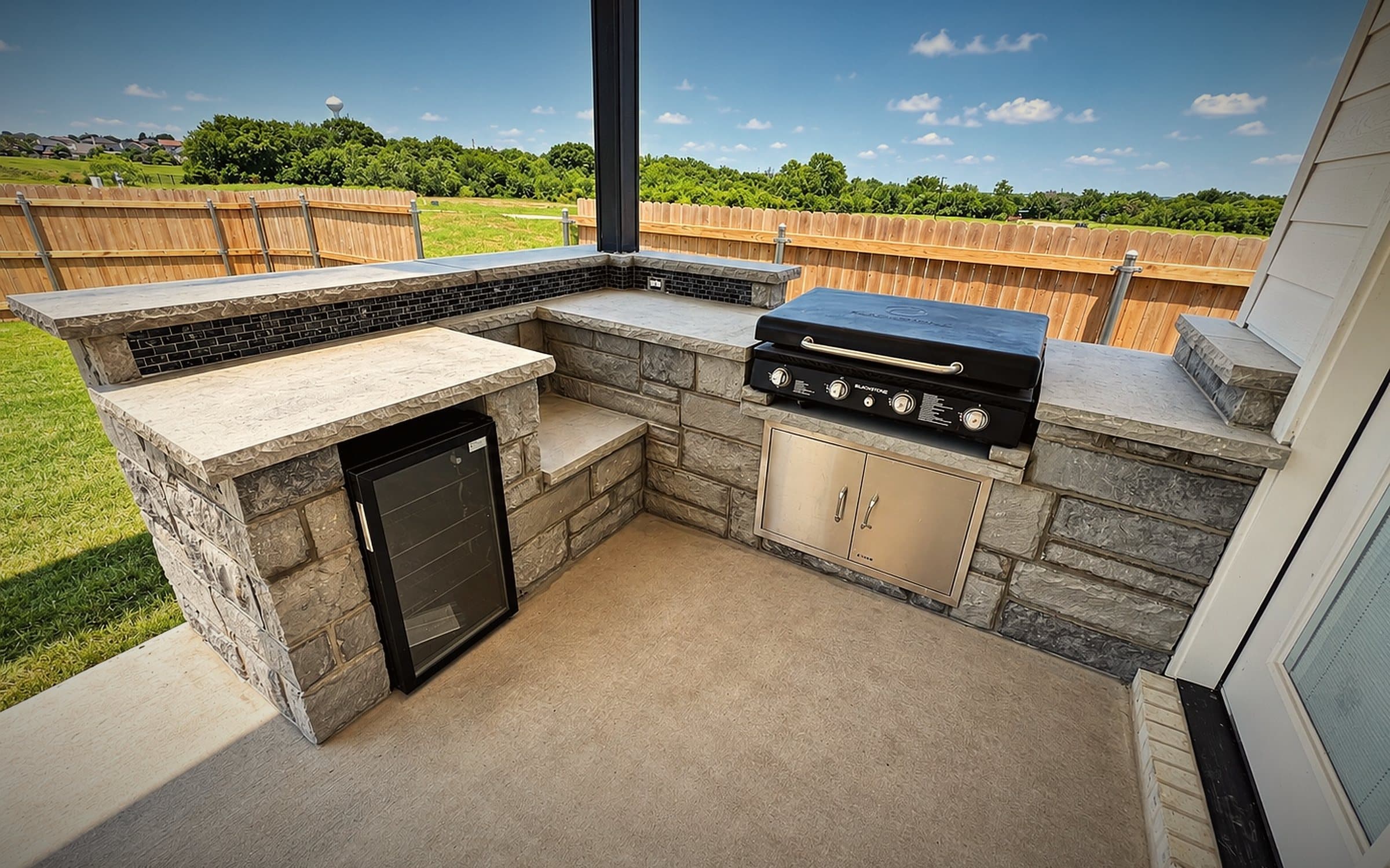 L-shaped limestone outdoor kitchen with built-in grill